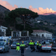 Italian Civil protection volunteers gather near the heavily damaged church of Maria Santissima as plumes of smoke come out the Mount Enta Volcano in Fleri, Sicily Italy, Wednesday, Dec. 26, 2018. A quake triggered by Italy's Mount Etna volcano has jolted eastern Sicily, slightly injuring 10 people and prompting frightened Italian villagers to flee their homes. (AP Photo/Salvatore Allegra)